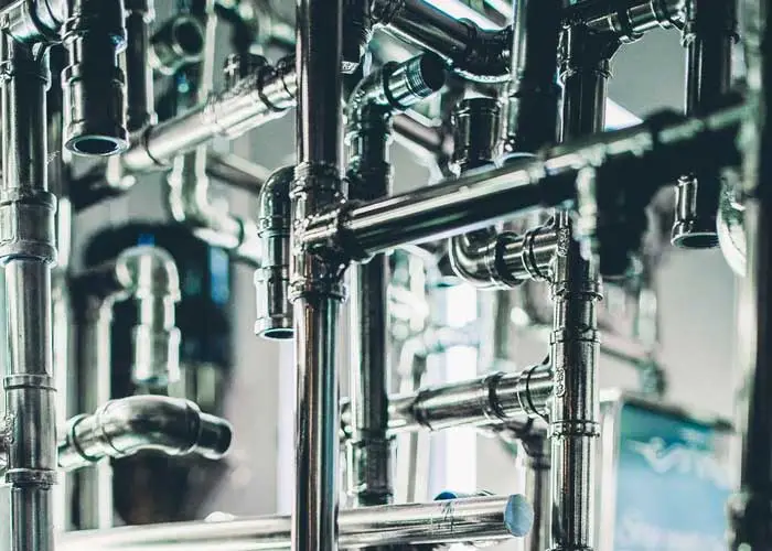 An intricate network of metal pipes and valves, suggesting an industrial or mechanical setting.