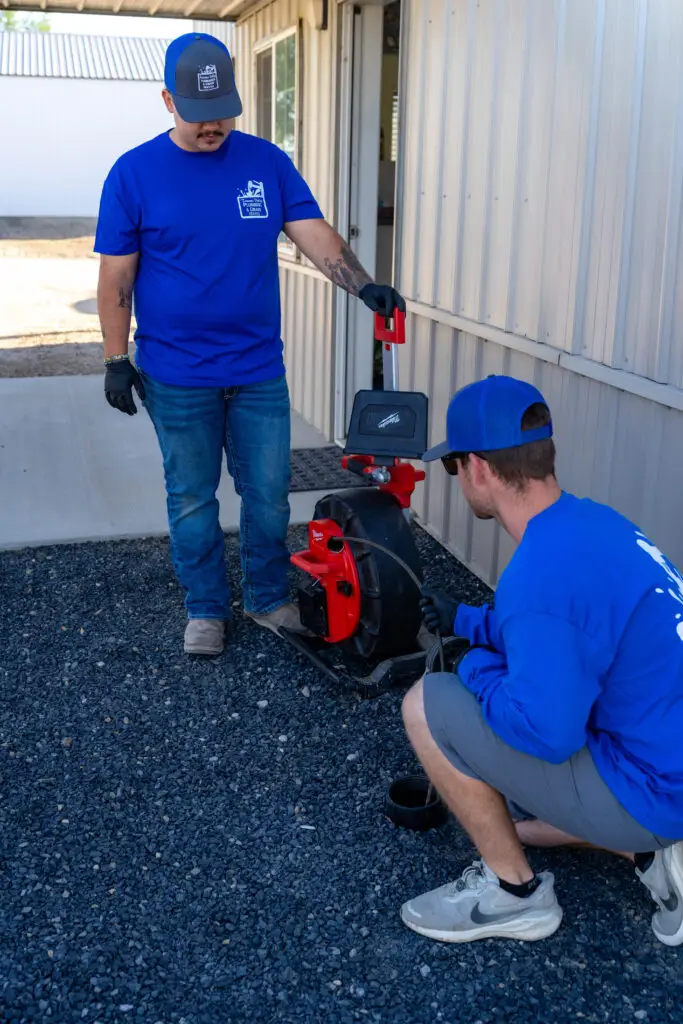 A plumber standing outside a building and working on something