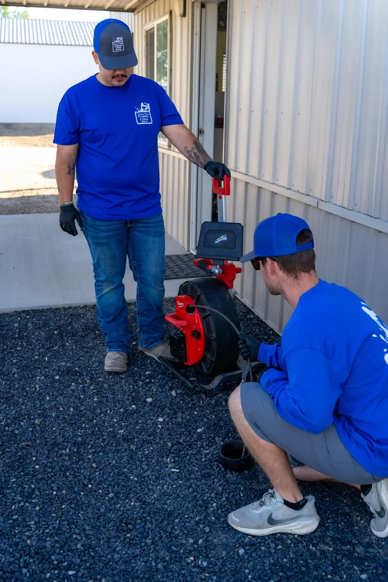 A plumber standing outside a building and working on something