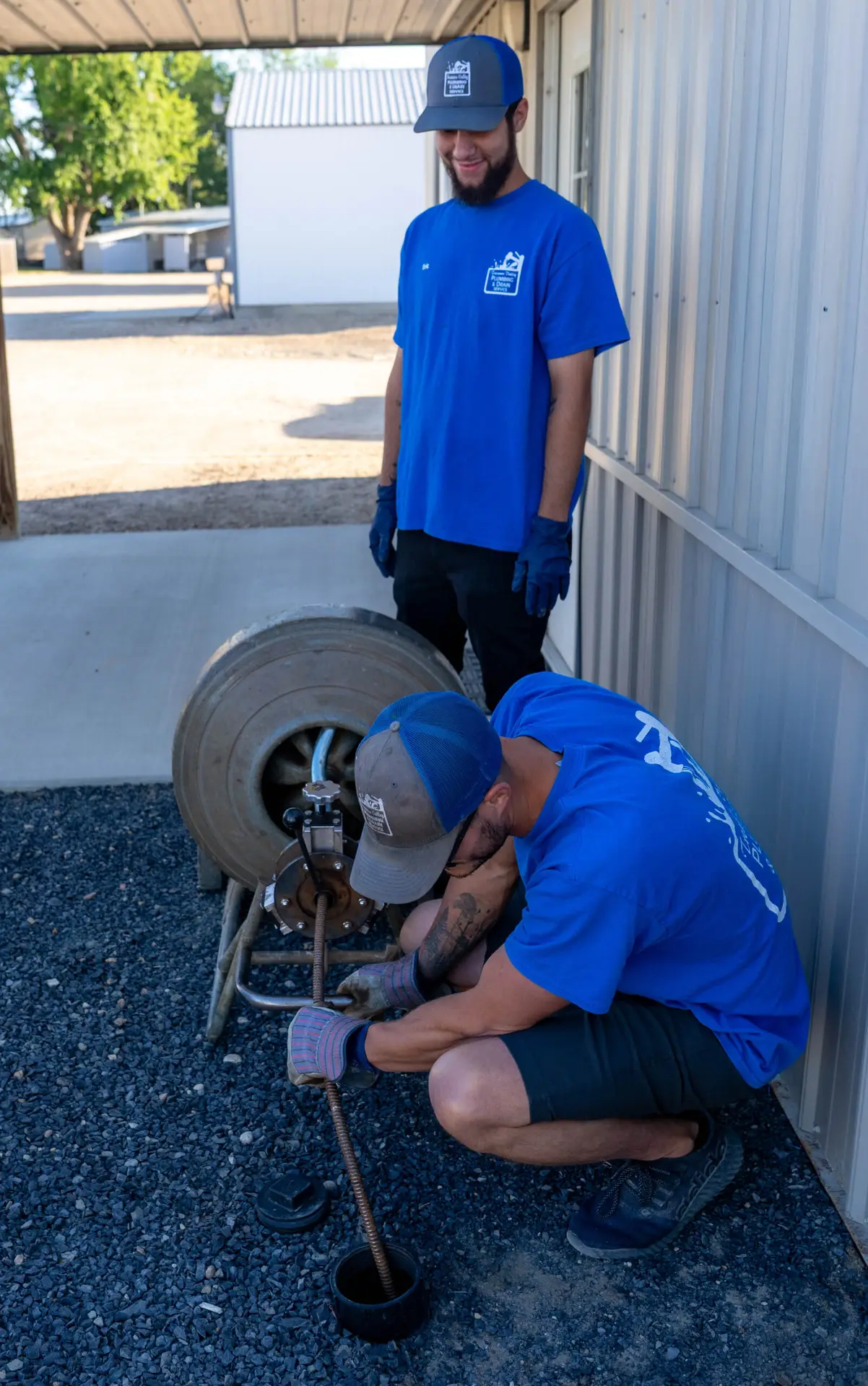 A plumber kneeling down and working on a piece of equipment